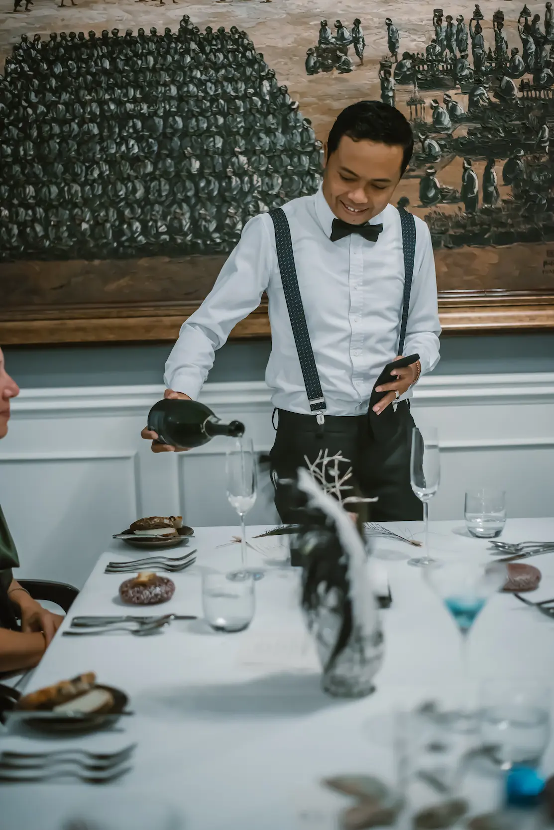A waiter pouring wine in Ubud