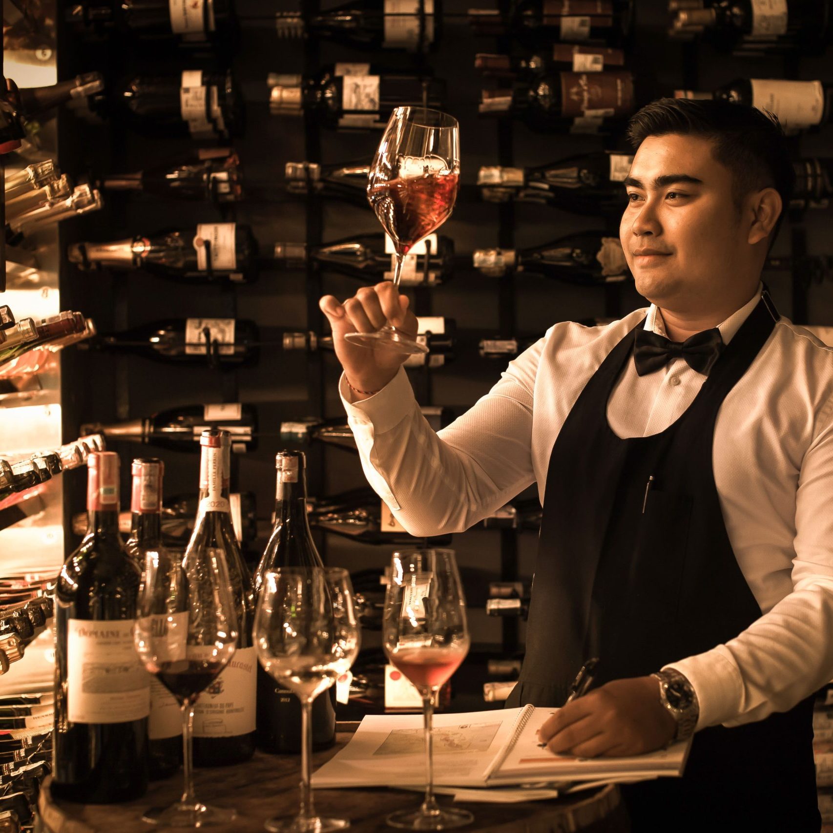 A staff member holding a glass of wine