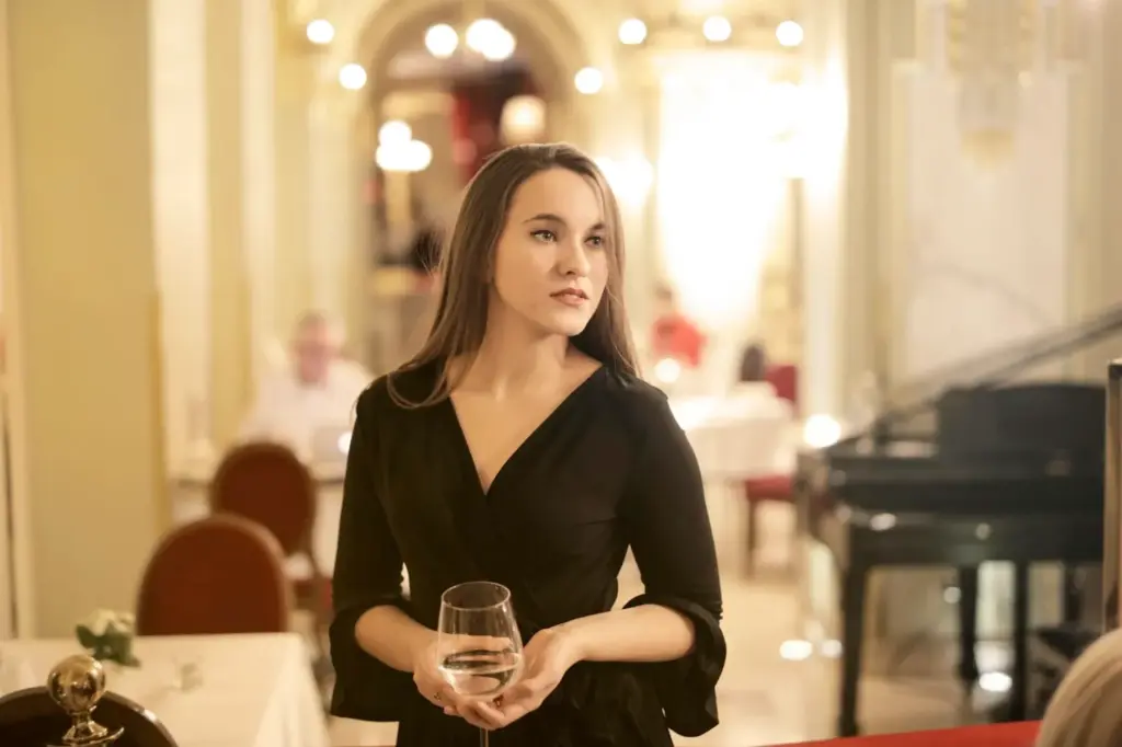 A woman holding a glass of wine in a fine dining venue