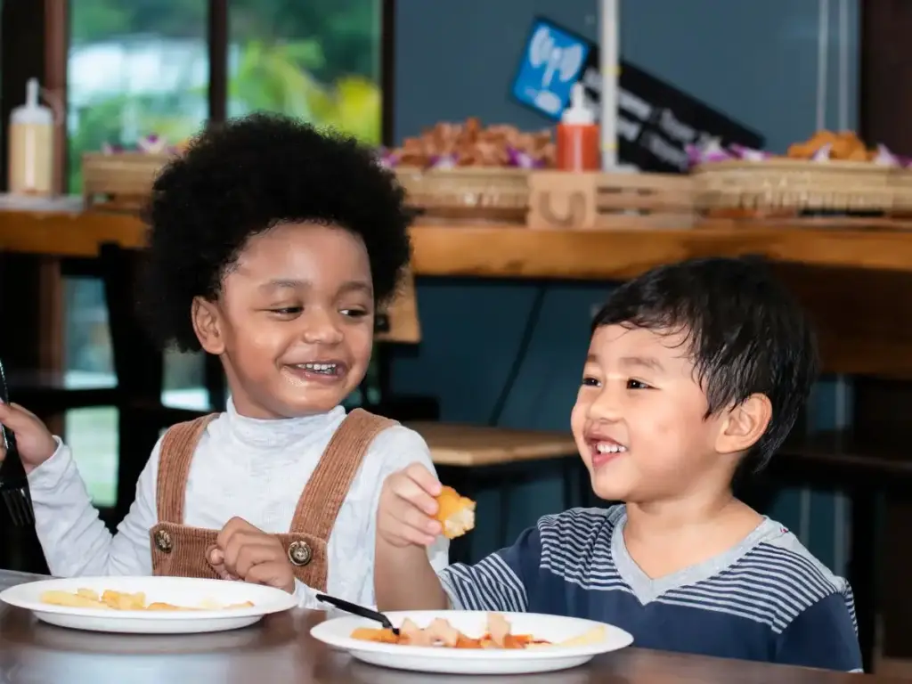 Two children eating meals