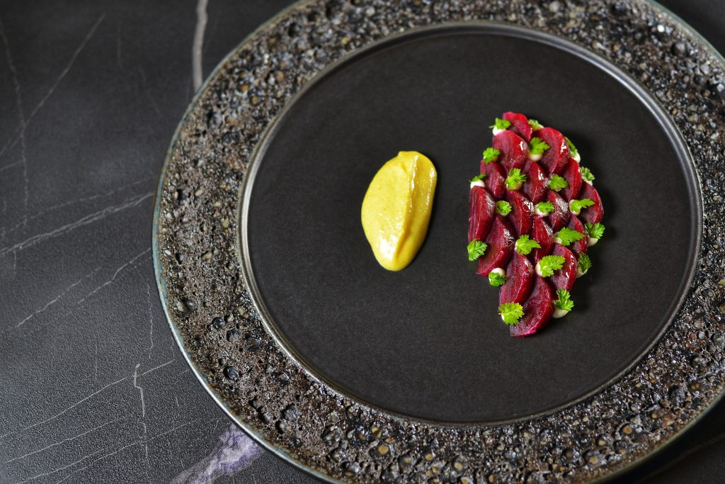 A fine dining starter course of beetroot with side sauce