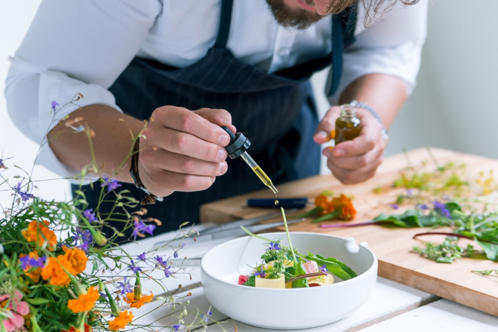 A fine dining chef adding the final touches to a meal