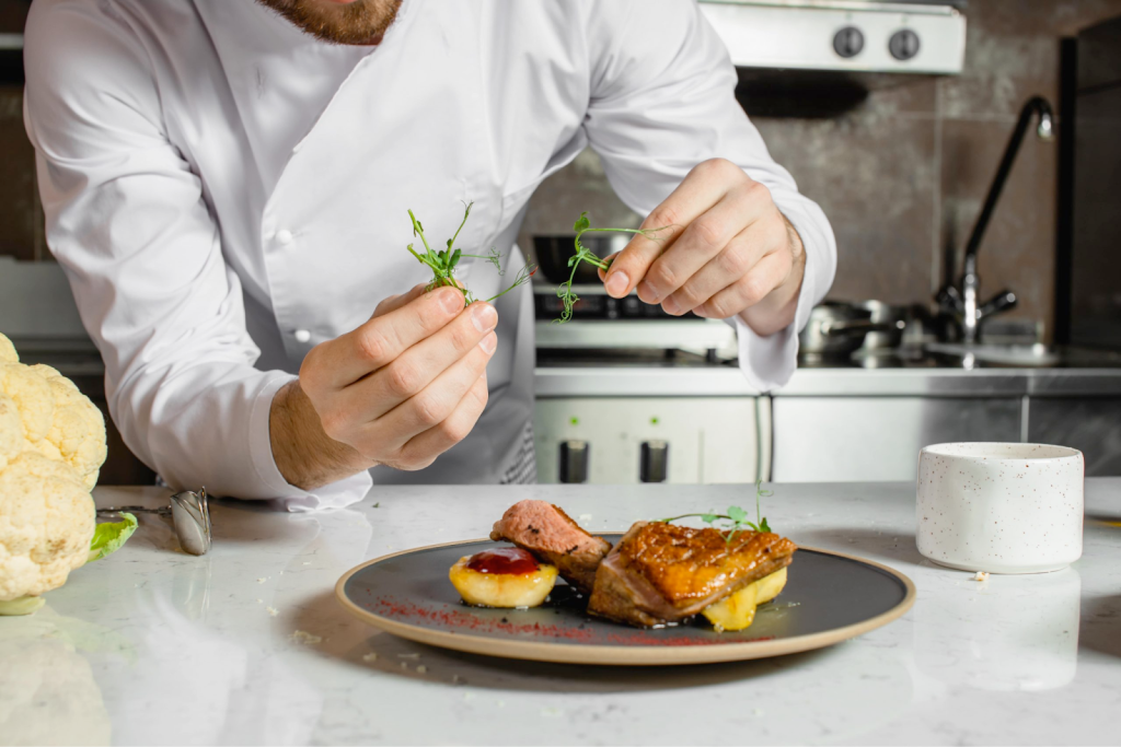A chef plating and presenting a gourmet meal