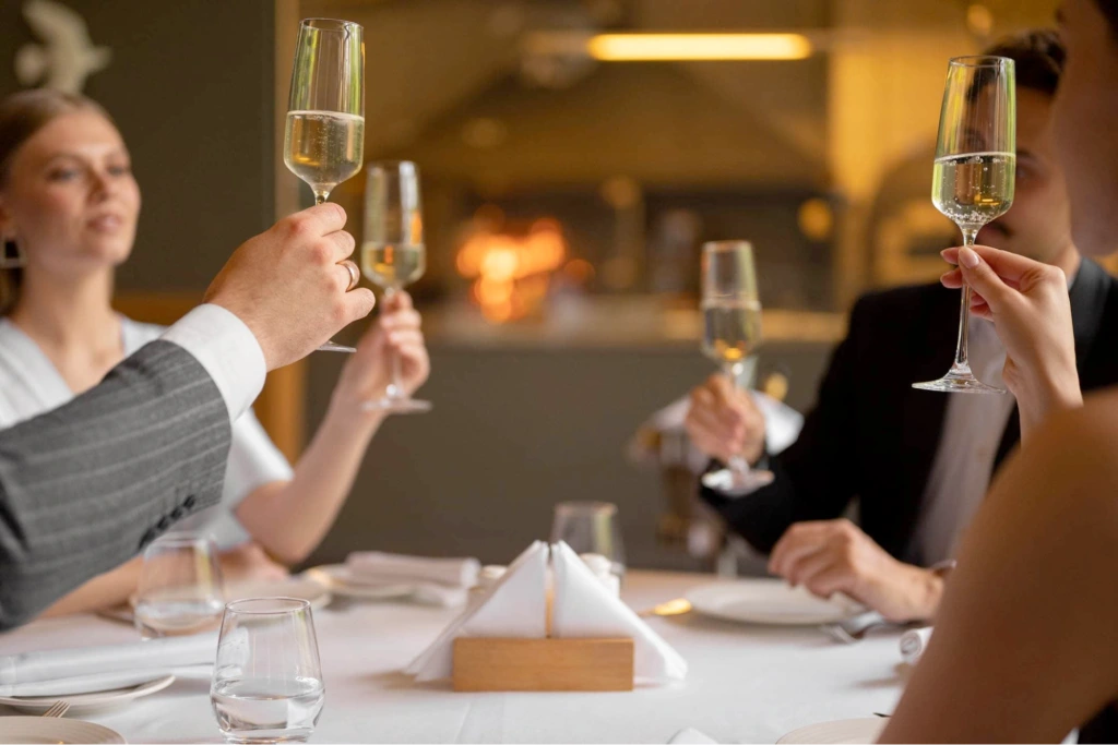 Diners cheering wine at a restaurant table