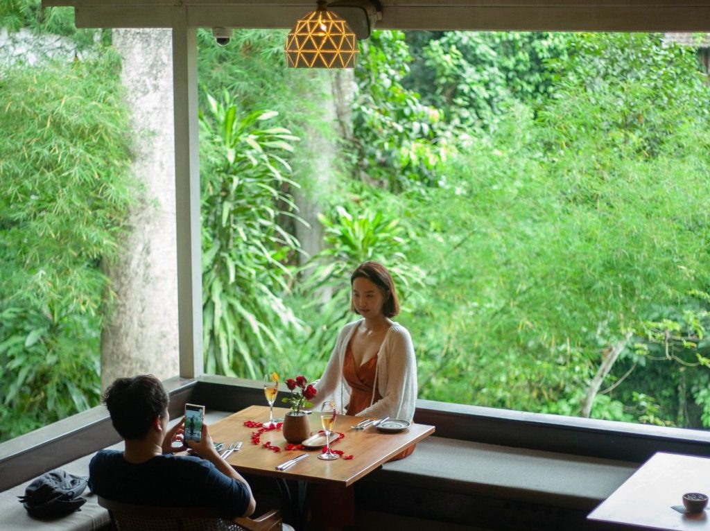 A couple dining at Arcadia restaurant in Ubud with jungle in background