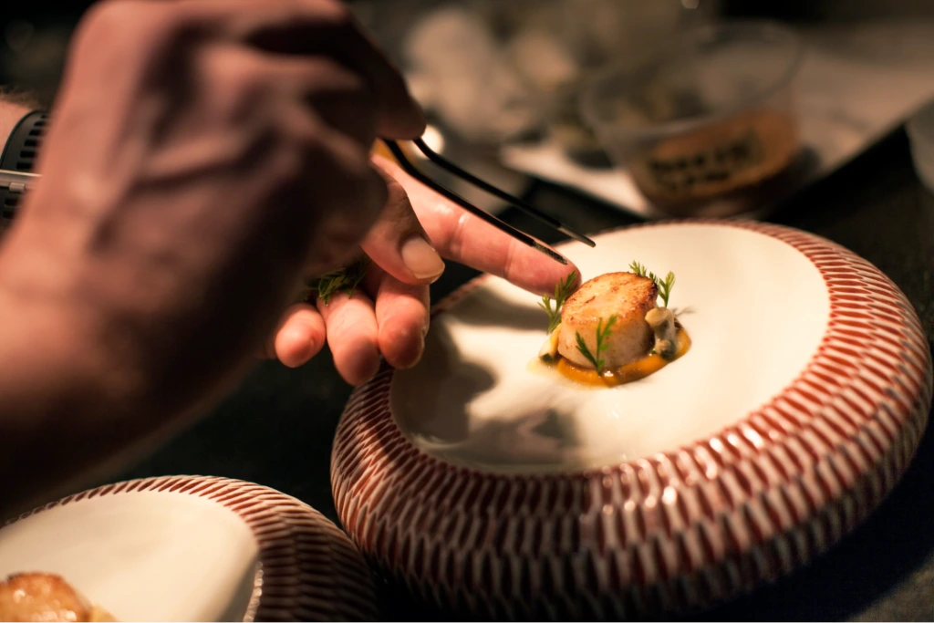 A fine dining appetiser of scallop with herbs
