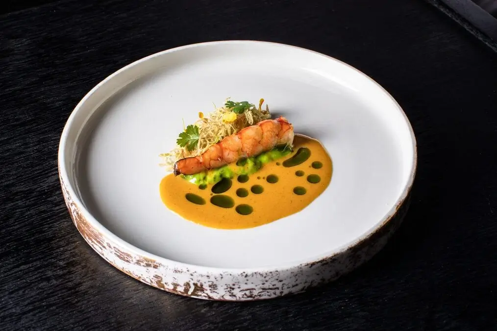 A gourmet dish of prawn and vegetables with sauce