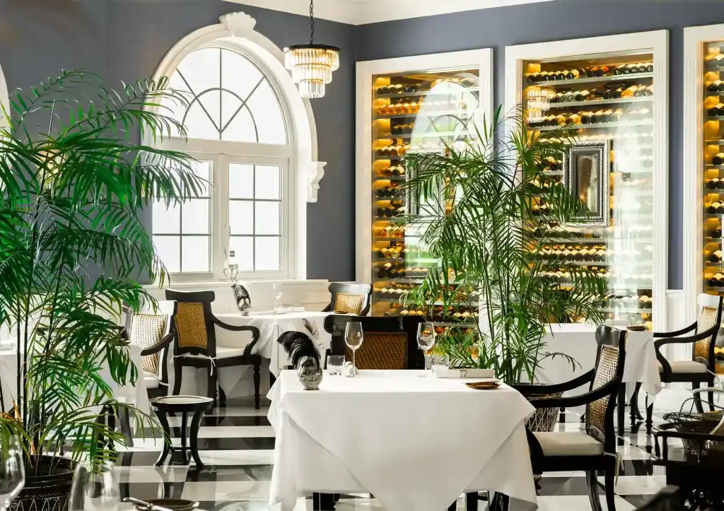 Elegant Bali fine dining restaurant with arched windows, wine racks, and romantic table setting.