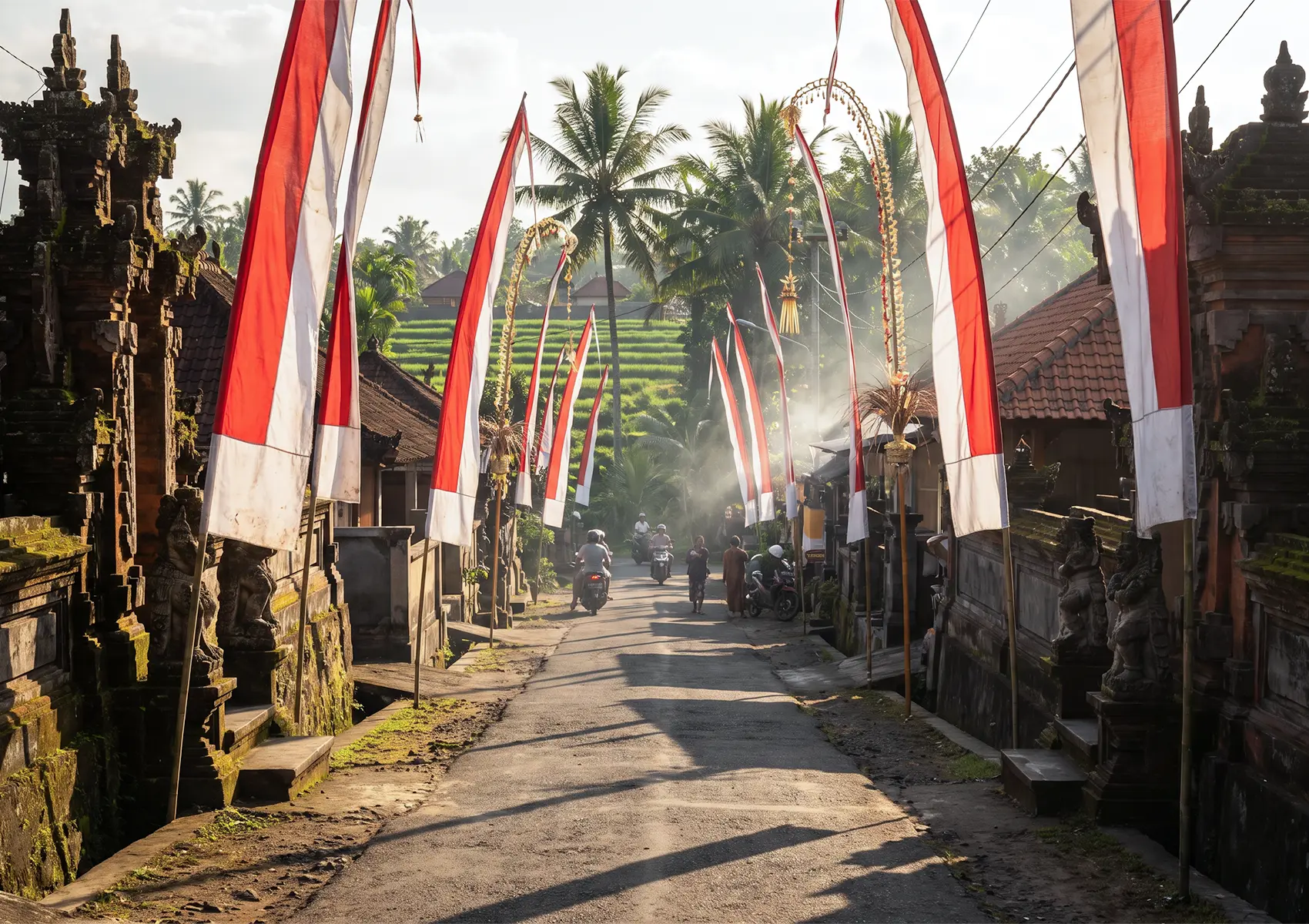 A picturesque village street lined with tall red and white flags and traditional penjor decorations for Indonesian Independence Day Bali.
